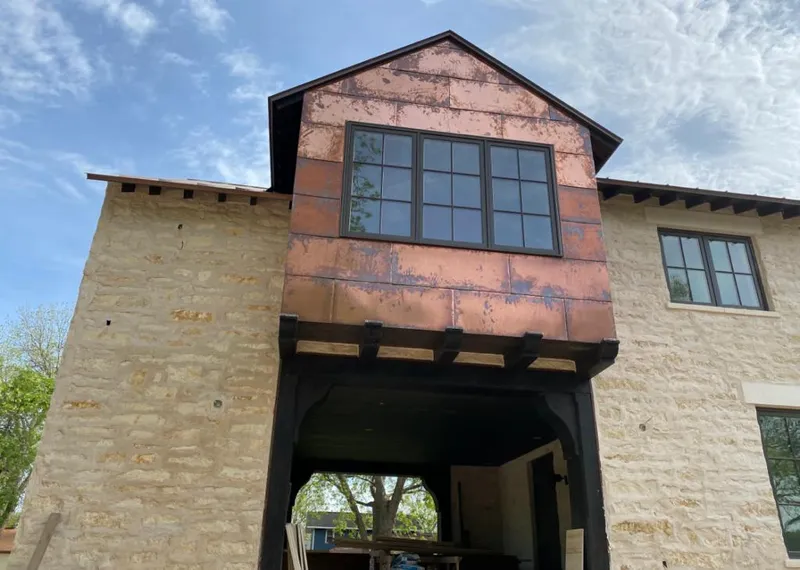 Copper metal panel facade on a stone building for Roof Repair in Porters Neck